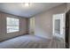 Bedroom featuring plush gray carpeting, neutral walls, window views, closet, and open door at 62 W Lakeview Dr, Temple, GA 30179