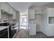 Well-lit kitchen with stainless steel appliances and durable countertops, open to the living area at 62 W Lakeview Dr, Temple, GA 30179