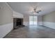 View of living room featuring a stone fireplace, ceiling fan, and sliding glass doors to the back deck at 62 W Lakeview Dr, Temple, GA 30179
