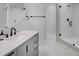 Modern bathroom features a glass walk-in shower, stylish vanity, round mirror and white hexagon tile at 700 N Island Dr, Atlanta, GA 30327