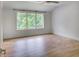 Bright bedroom features hardwood floors, a ceiling fan, and a large window with a view of lush greenery at 700 N Island Dr, Atlanta, GA 30327