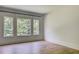 This bedroom features hardwood floors and a view of the trees visible through the large windows at 700 N Island Dr, Atlanta, GA 30327