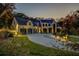 Exterior of grand home at dusk, with landscape lighting and a circular driveway at 700 N Island Dr, Atlanta, GA 30327