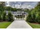Gated entrance to an elegant home featuring manicured landscaping and mature trees at 700 N Island Dr, Atlanta, GA 30327