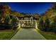 Gated home entrance with long driveway, manicured lawn, and mature trees at 700 N Island Dr, Atlanta, GA 30327