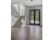 Bright foyer with staircase, wood floors, modern light fixture, and a view of the front yard at 700 N Island Dr, Atlanta, GA 30327