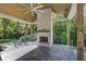 Covered porch with stone fireplace, ceiling fan, and wooded view at 700 N Island Dr, Atlanta, GA 30327