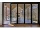Covered porch features a stone fireplace, wood ceiling, and folding glass doors at 700 N Island Dr, Atlanta, GA 30327