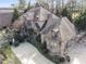 An aerial view shows this stately home's stone and brick facade, mature trees, and curved driveway at 3871 Trickum Road Ne, Marietta, GA 30066