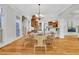 Bright dining area featuring hardwood floors, a modern chandelier, and an elegant, round glass-top table with seating for six at 3871 Trickum Road Ne, Marietta, GA 30066