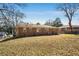 Rear view of a classic brick home highlighting the ample backyard space with mature trees and sunny exposure at 2631 Miriam Ln, Decatur, GA 30032