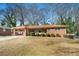 Traditional brick house featuring a covered carport and mature trees in the yard at 2631 Miriam Ln, Decatur, GA 30032