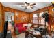 Living room with wood-paneled walls, ceiling fan, and two windows at 2631 Miriam Ln, Decatur, GA 30032