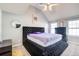 Bright bedroom features a plush, oversized, black platform bed, light gray walls, and large windows at 4119 Ravenwood Ct, Union City, GA 30291