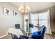 Cozy dining room with a glass table and blue velvet chairs, bathed in natural light at 4119 Ravenwood Ct, Union City, GA 30291