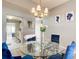 Elegant dining room with a glass table, blue chairs, and modern light fixture at 4119 Ravenwood Ct, Union City, GA 30291
