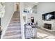Inviting living room with stairs, gray tufted sofa, and fireplace at 4119 Ravenwood Ct, Union City, GA 30291