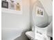 Modern powder room features a pedestal sink, round mirror, and decorative perfume artwork at 4119 Ravenwood Ct, Union City, GA 30291