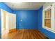 Room with blue wood paneling, wood floors, and a boarded window at 1046 Katherwood Sw Dr, Atlanta, GA 30310