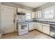 Kitchen with dated appliances, cream cabinets and dingy tile flooring at 1046 Katherwood Sw Dr, Atlanta, GA 30310