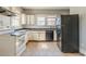 Kitchen with dated appliances, cream cabinets and dingy tile flooring at 1046 Katherwood Sw Dr, Atlanta, GA 30310