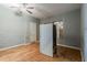 Room with gray walls, wood floors, and boarded window next to refrigerator at 1046 Katherwood Sw Dr, Atlanta, GA 30310