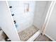 Stylish shower with floor-to-ceiling white tiles, a built-in niche, and a pebble-stone shower floor at 3981 Rocmar Dr, Snellville, GA 30039