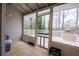 Enclosed sunroom with multiple windows offering a panoramic view of the surrounding outdoor scenery and a wooden deck at 3981 Rocmar Dr, Snellville, GA 30039