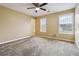 The bedroom has neutral colored walls and plush carpet; natural light comes from the two large windows at 6374 Rockaway Rd, Atlanta, GA 30349