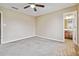 This bedroom features neutral walls, plush carpet and a ceiling fan at 6374 Rockaway Rd, Atlanta, GA 30349