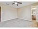 This bedroom features neutral walls, plush carpet, a ceiling fan, and an ensuite bath at 6374 Rockaway Rd, Atlanta, GA 30349