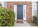 Inviting front entrance with a dark-colored door, sidelights, and brick exterior at 6374 Rockaway Rd, Atlanta, GA 30349