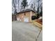 View of the home's rear exterior featuring a three-car garage and tiered landscaping at 1285 Glandor Se Ct, Mableton, GA 30126