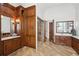 Spacious bathroom features beautiful wood cabinets, marble counters, a glass shower, and stylish lighting at 440 Belada Blvd, Sandy Springs, GA 30342