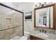 Bathroom featuring a glass-enclosed shower, granite countertop, and decorative mirror at 440 Belada Blvd, Sandy Springs, GA 30342