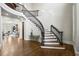 Grand foyer with hardwood floors, curved staircase with iron railings, and a view into the living room at 440 Belada Blvd, Sandy Springs, GA 30342