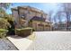 Three car garage featuring an extra wide brick driveway and mature landscaping at 440 Belada Blvd, Sandy Springs, GA 30342