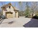 Spacious three car garage with brick driveway, stone gate posts, and mature trees at 440 Belada Blvd, Sandy Springs, GA 30342