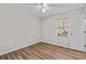 A well-lit bedroom includes wood floors, a ceiling fan, and a window with a view of outside at 6165 Picketts Nw Rdg, Acworth, GA 30101