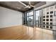 Living room featuring hardwood floors, exposed concrete ceiling, and floor to ceiling windows with city views at 943 Peachtree Ne St # 2009, Atlanta, GA 30309