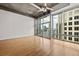 Living room featuring hardwood floors, exposed concrete ceiling, and floor to ceiling windows with city views at 943 Peachtree Ne St # 2009, Atlanta, GA 30309