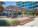 Condo's outdoor patio with pergola, dining area, and lush landscaping, perfect for relaxing and entertaining at 943 Peachtree Ne St # 2009, Atlanta, GA 30309