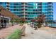 Beautiful condo patio boasts multiple seating areas with lush green landscaping and views of the building at 943 Peachtree Ne St # 2009, Atlanta, GA 30309