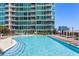 Condo swimming pool features sparkling blue water, lounge chairs, and views of the surrounding buildings at 943 Peachtree Ne St # 2009, Atlanta, GA 30309