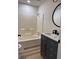 Bathroom features vanity with grey cabinets, a round mirror and shower-tub combo at 2520 Deerfield Nw Dr, Kennesaw, GA 30144