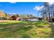 Wide shot of the property's exterior, featuring ample green space, mature trees, and a charming facade at 409 Shannon Way, Lawrenceville, GA 30044
