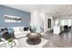 Spacious living room featuring a white sofa, gray accent wall, modern art, and an open layout with the kitchen and dining area at 345 Skylar Se Way, Atlanta, GA 30315