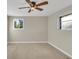 Neutral bedroom with carpet, two windows, and a dark-colored ceiling fan at 6198 Rocky Creek Dr, Douglasville, GA 30135