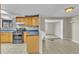 The kitchen features tile floors, stainless steel appliances, and wooden cabinets with a view of the living room at 6198 Rocky Creek Dr, Douglasville, GA 30135