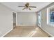 Spacious living room featuring neutral paint, carpet floors, a ceiling fan, and a large glass paneled door and window at 6198 Rocky Creek Dr, Douglasville, GA 30135